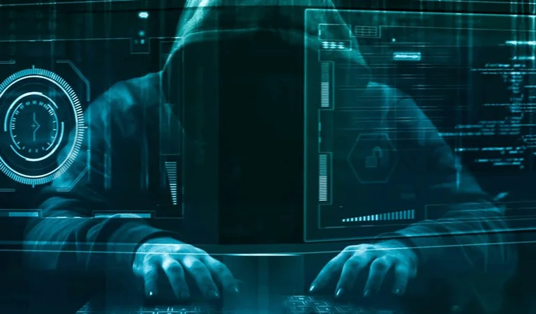 A close-up of a hooded figure typing on a keyboard, surrounded by floating digital data and security visuals in a dark, futuristic setting.